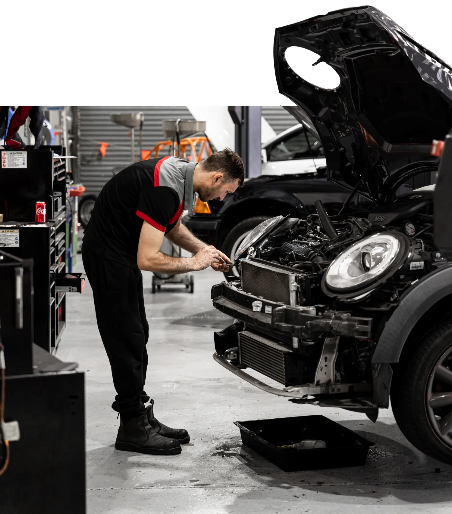 Mechanic performing log book service on BMW at European car repair workshop Brisbane