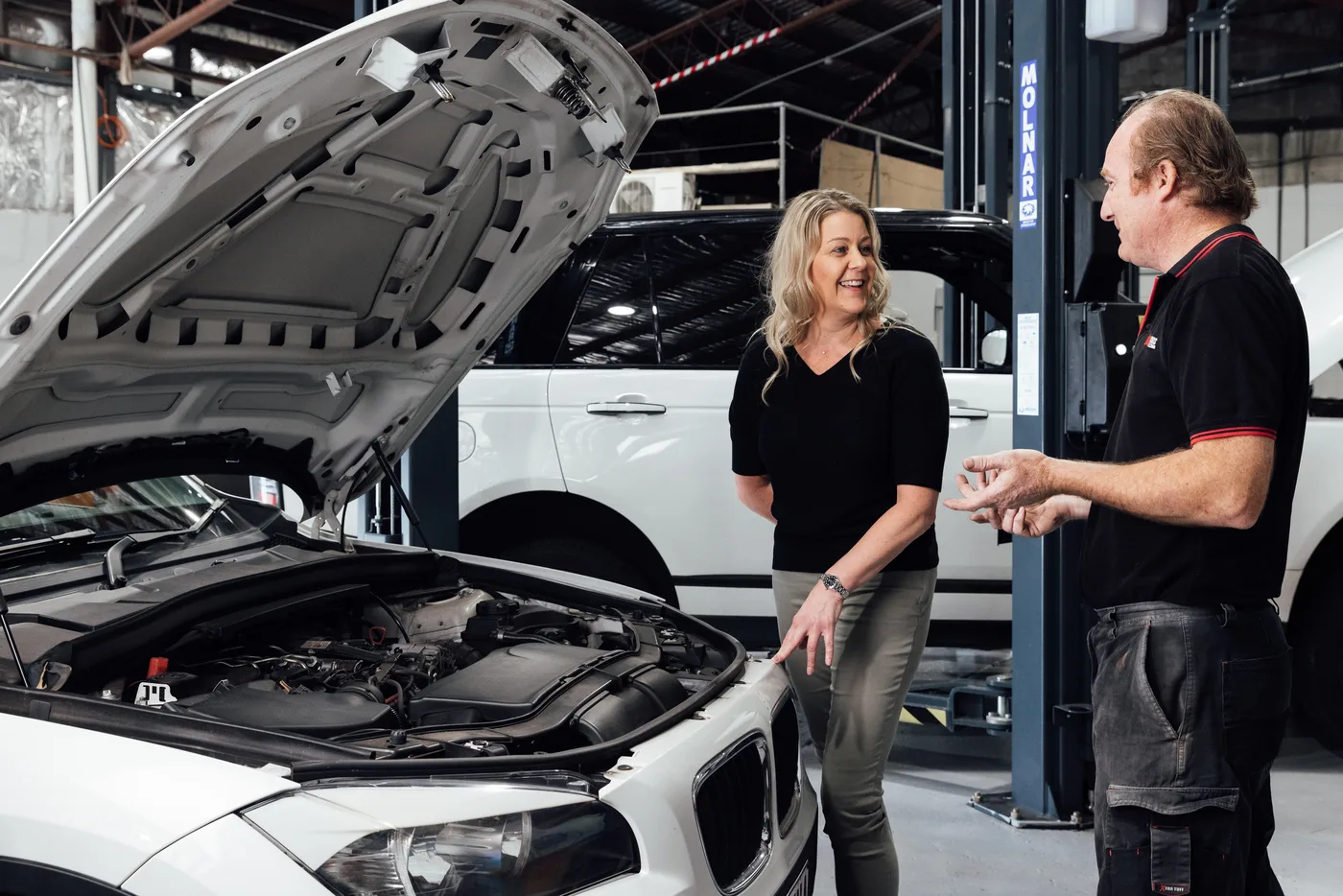 Bosch Service Brisbane mechanic walking a customer through a pre purchase inspection under the bonnet of a BMW